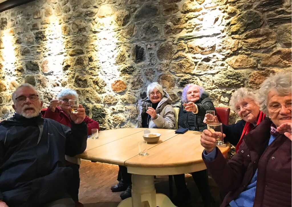Members enjoying a wee dram at the end of a busy day of siteseeing in their Highland Holiday.